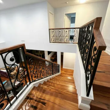 Custom wrought iron staircase with wooden steps and ornate railing design