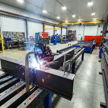 Professional metal fabrication workshop with sparks flying from welding work in Costa Mesa
