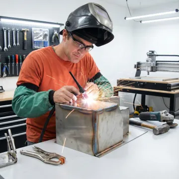 Skilled welder creating custom metal fabrication with precision equipment