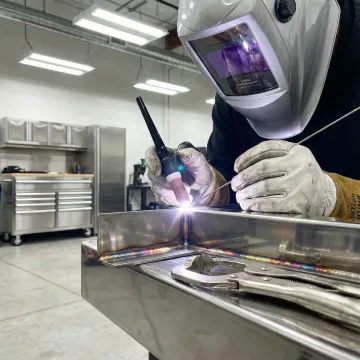 Professional TIG welder performing precision welding on stainless steel fabrication in Anaheim workshop