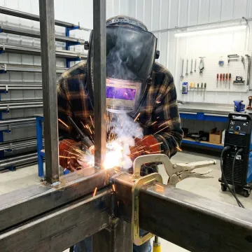 Commercial steel fence installation process showing professional welding and fabrication work