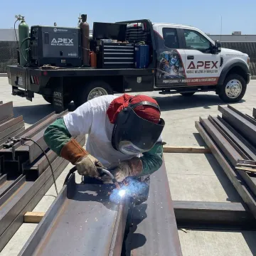 Professional mobile welder working on structural steel fabrication at job site