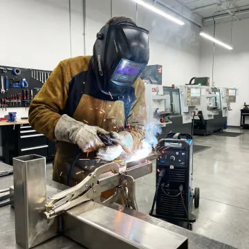 Professional welder fabricating custom metal structure in workshop