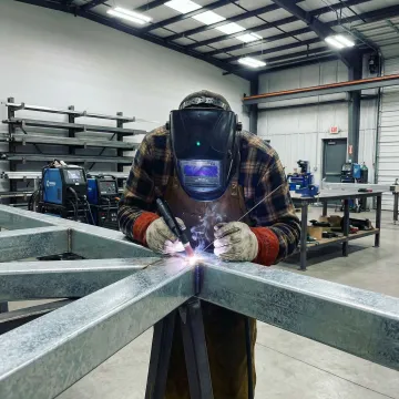 Professional welder working on galvanized steel custom fabrication project