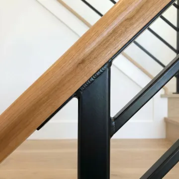 Custom fabricated metal staircase railing with wood integration