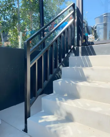 Skilled welder fabricating custom iron railing with precision tools