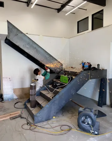 Craftsman welding ornamental iron railing with precision