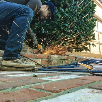 Custom metal fabrication workshop with skilled welder working on ornate ironwork design