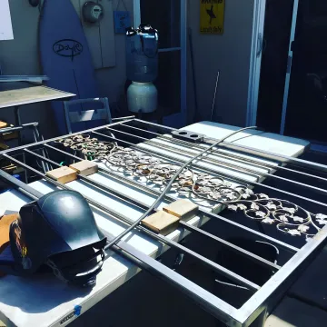 Commercial automatic gate repair technician working on gate motor system