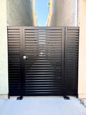 Professional gate installation team setting up custom wrought iron gate