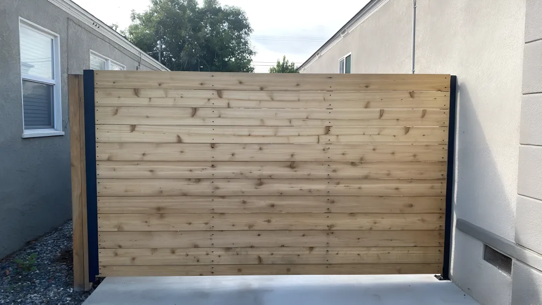 Craftsman welding custom iron gate design in workshop