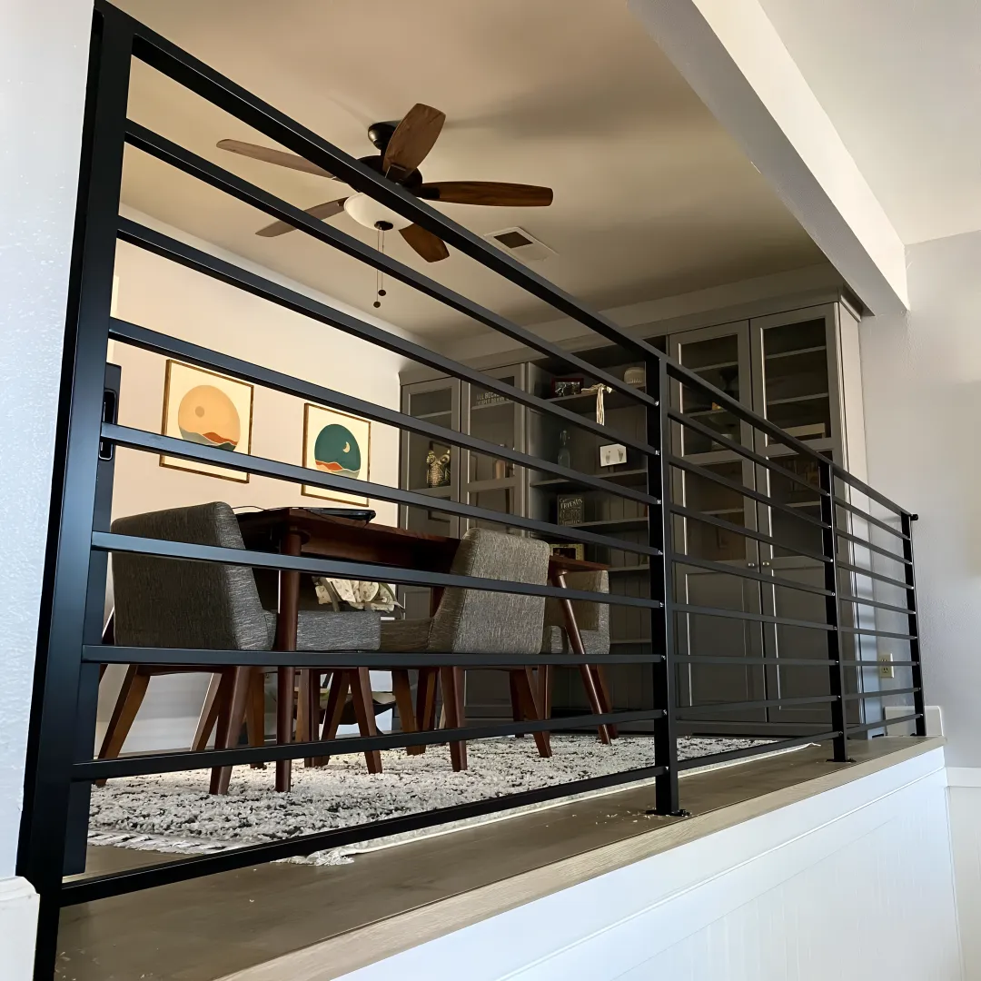 Skilled craftsman welding custom wrought iron railing in workshop