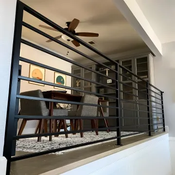 Skilled craftsman welding custom wrought iron railing in workshop