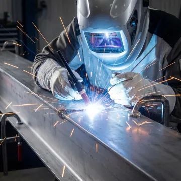 Professional welder performing precision TIG welding on structural steel in Laguna Hills workshop