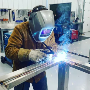 Professional welder working on metal fabrication project in Lake Forest workshop