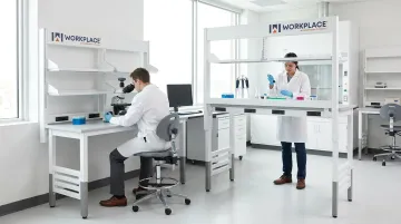Height-adjustable laboratory workbench showing manual and motorized sit-to-stand range