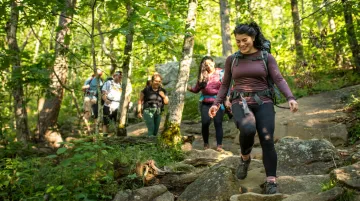 Corporate team hiking outdoors on a guided nature trail retreat activity