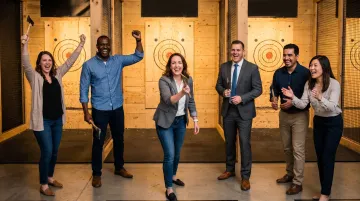 Corporate team participating in competitive axe throwing event at indoor venue