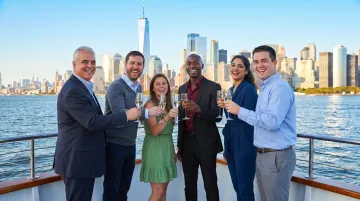 Corporate group enjoying private NYC harbor cruise with Manhattan skyline backdrop