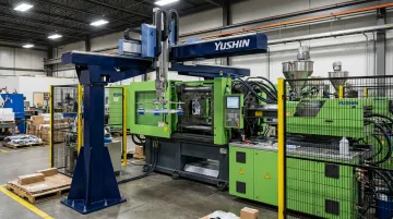 Yushin America take-out robot operating inside injection molding production cell