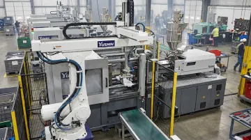 Yushin linear take-out robot extracting parts from injection molding machine in production cell