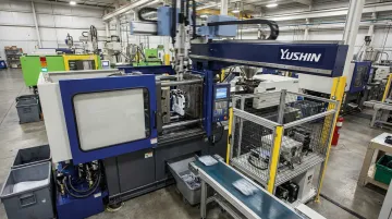 Yushin America injection molding automation robot installed on active production press