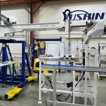 Technician reviewing take-out robot automation at molding machine