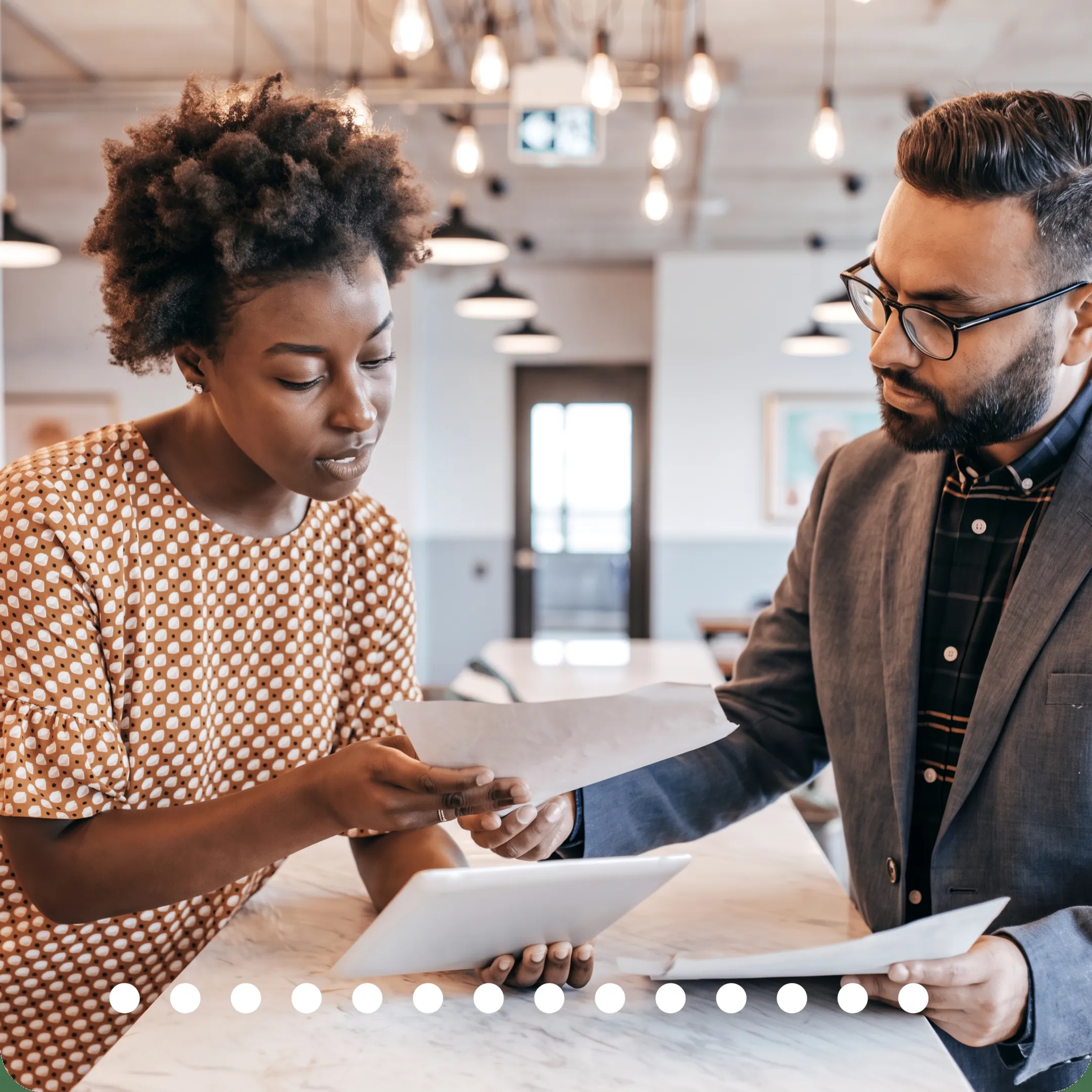 Advisor reviewing tax documents and financial reports with a business owner